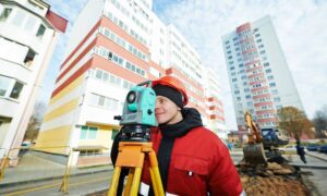 Professional surveyor conducting an ALTA land survey at a large commercial property before closing