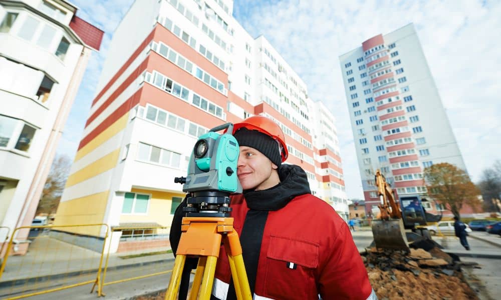 Professional surveyor conducting an ALTA land survey at a large commercial property before closing