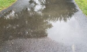 Driveway water pooling after rain - ALTA SURVEY Illinois Water pooling on a driveway after a storm, showing drainage issues that an elevation survey can help identify