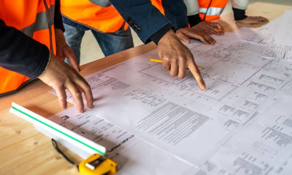 site layout zoning compliance planning - ALTA SURVEY Illinois Engineers reviewing construction blueprints to ensure accurate site layout and zoning compliance before redevelopment.