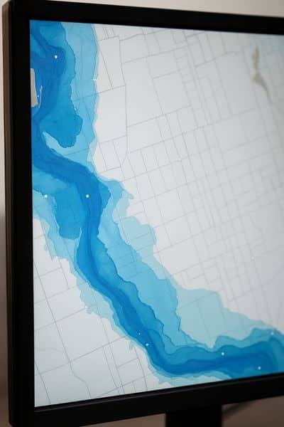 Flood elevation survey risk map visual - ALTA SURVEY Illinois Computer screen displaying a flood risk map with blue shaded zones created from a flood elevation survey and local flood data
