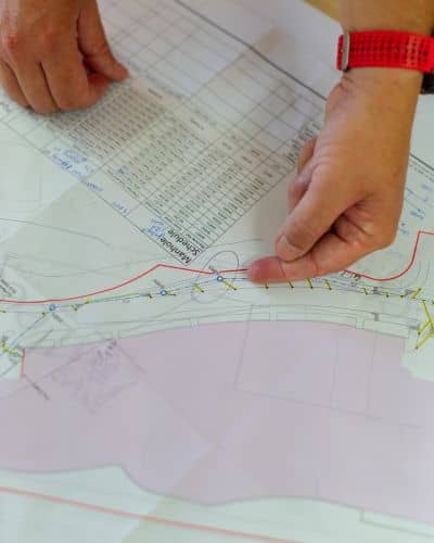 Technical construction blueprint review - ALTA SURVEY Illinois Hands reviewing a technical site plan used for a construction survey on a development project