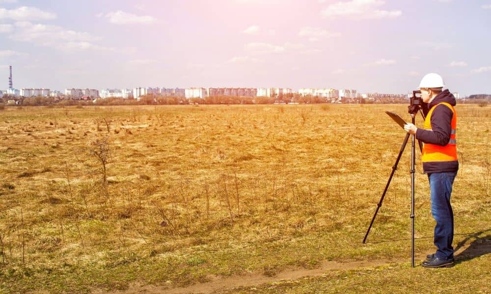 A professional land surveying expert using precision equipment to measure ground elevation and site conditions