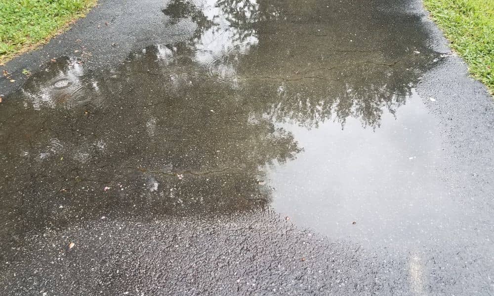 Driveway water pooling after rain - ALTA SURVEY Illinois Water pooling on a driveway after a storm, showing drainage issues that an elevation survey can help identify